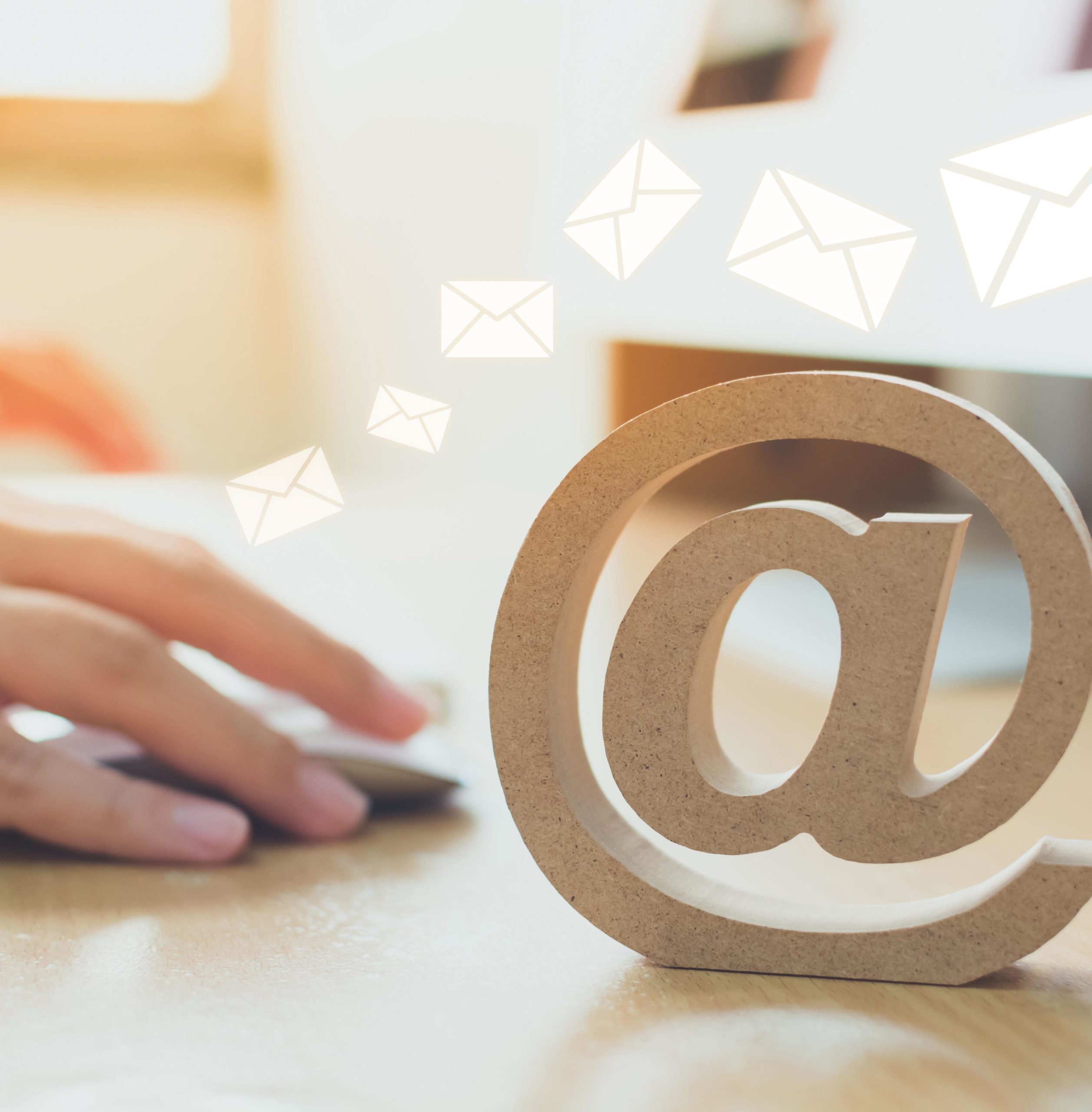 Email marketing concept, Hand using computer sending message with wooden email address symbol and envelope icon
